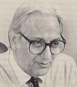 An older man with slightly long white hair wearing glasses.